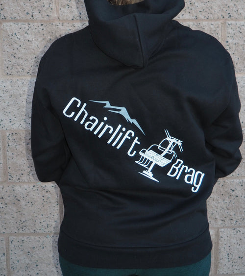 Black hoodie with 'Chairlift Brag' text and graphic on a stone wall background