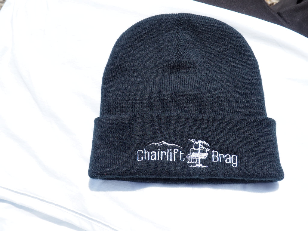Black beanie with 'Chairlift Brag' logo on a white background